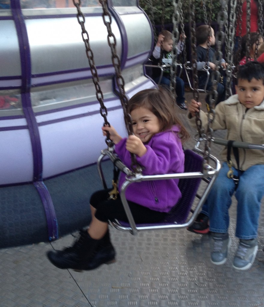 little girl riding swing ride at Six Flags, taking little kids to Six Flags over Texas