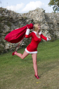 Female Santa running with sack of Christmas presents