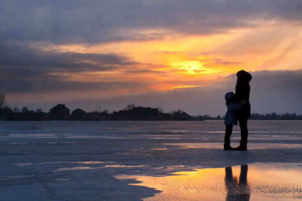 silhouette of a mother and child at sunset in winter