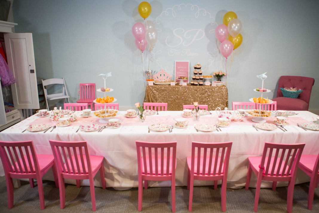 A table set for a party with balloons, plates, silverware, and balloons.