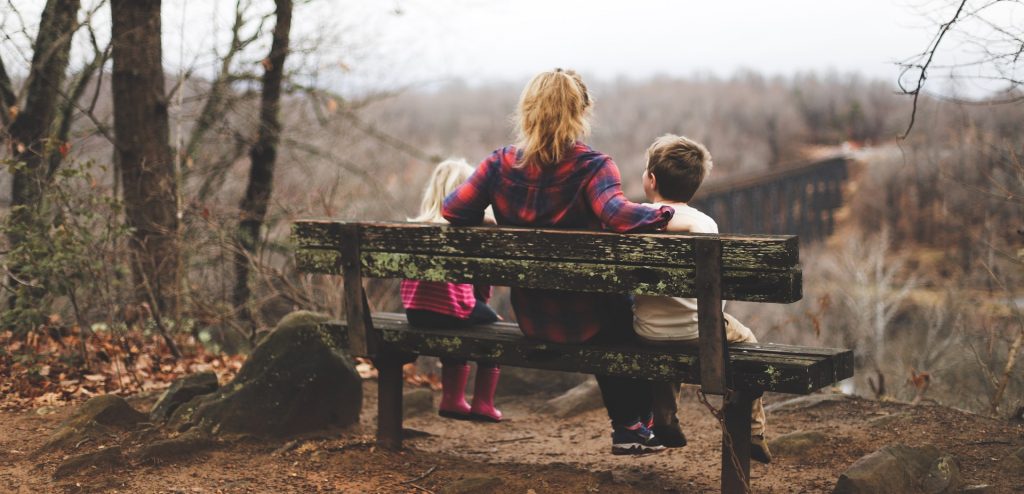 view of woman and two children on a bench from behind, how to support friends who are adopting
