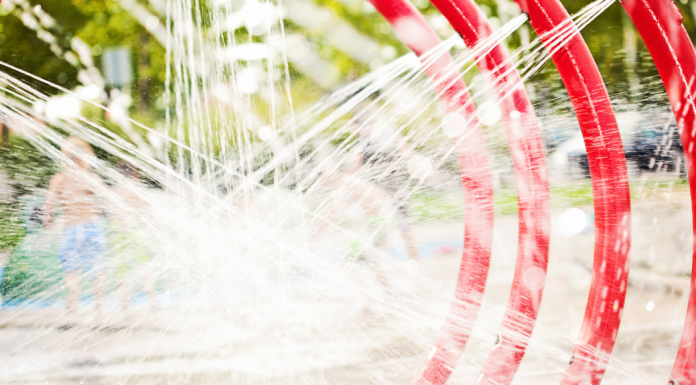 close-up of splash pad water feature (consecutive red hoops spraying water)