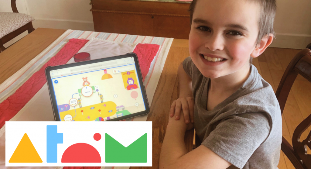 child smiling next to tablet, Atom Learning review