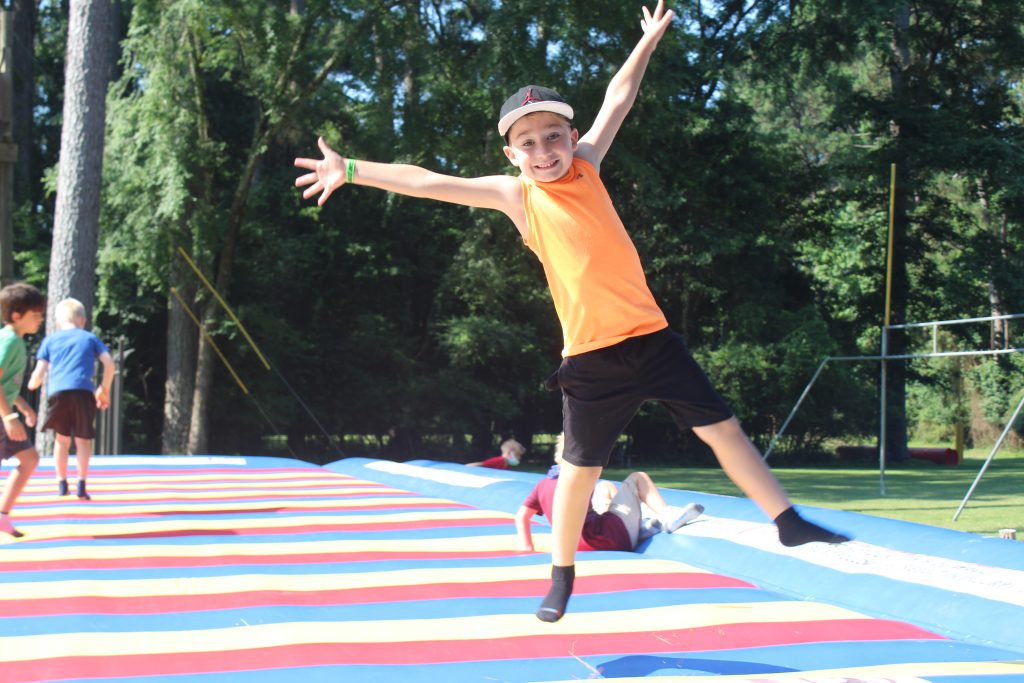 boy umping on inflatable at Camp Olympia