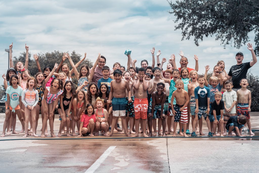 Big group of smiling campers in swimsuits at Camp Skylark Dallas