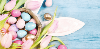 pastel and golden Easter eggs, bunny ears and tulips on a table