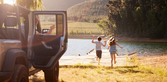 2 kids exiting car and running towards a dock at a lake, road trip products for kids