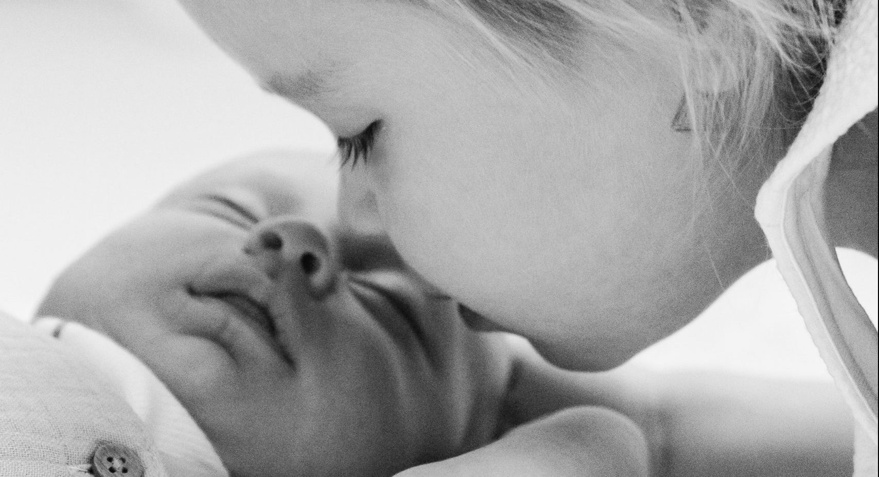 toddler kissing infant, celebrate your sibling, national siblings day