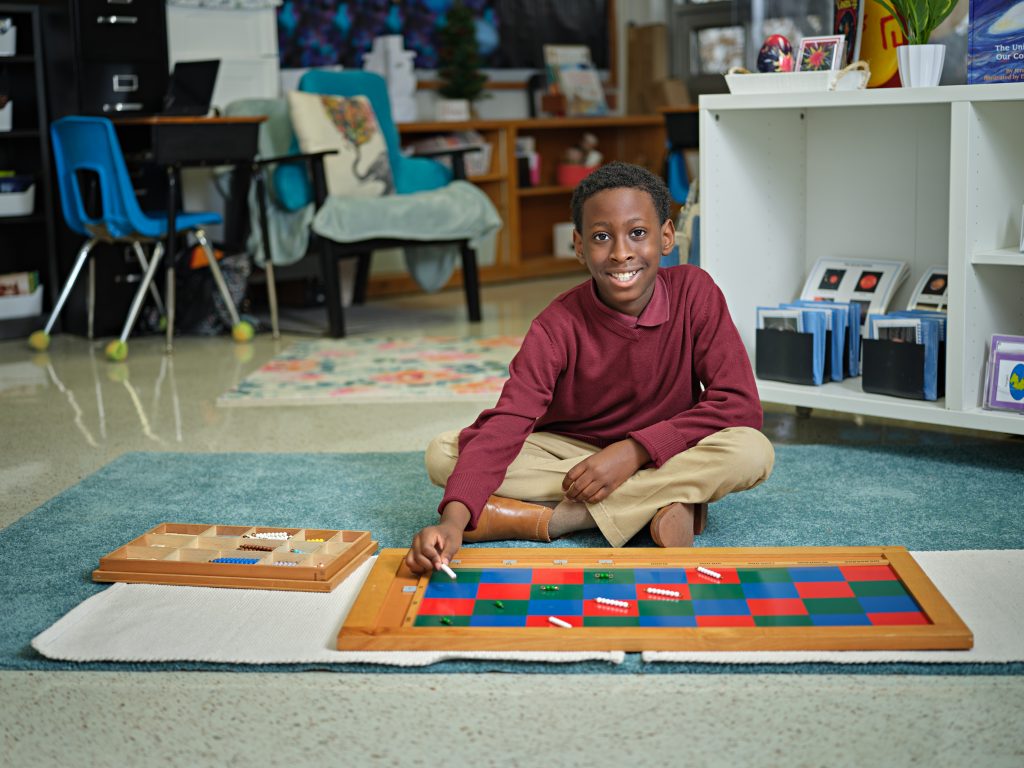 young Black student smiling while working on art project at school, good DISD schools