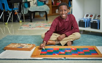 young Black student smiling while working on art project at school