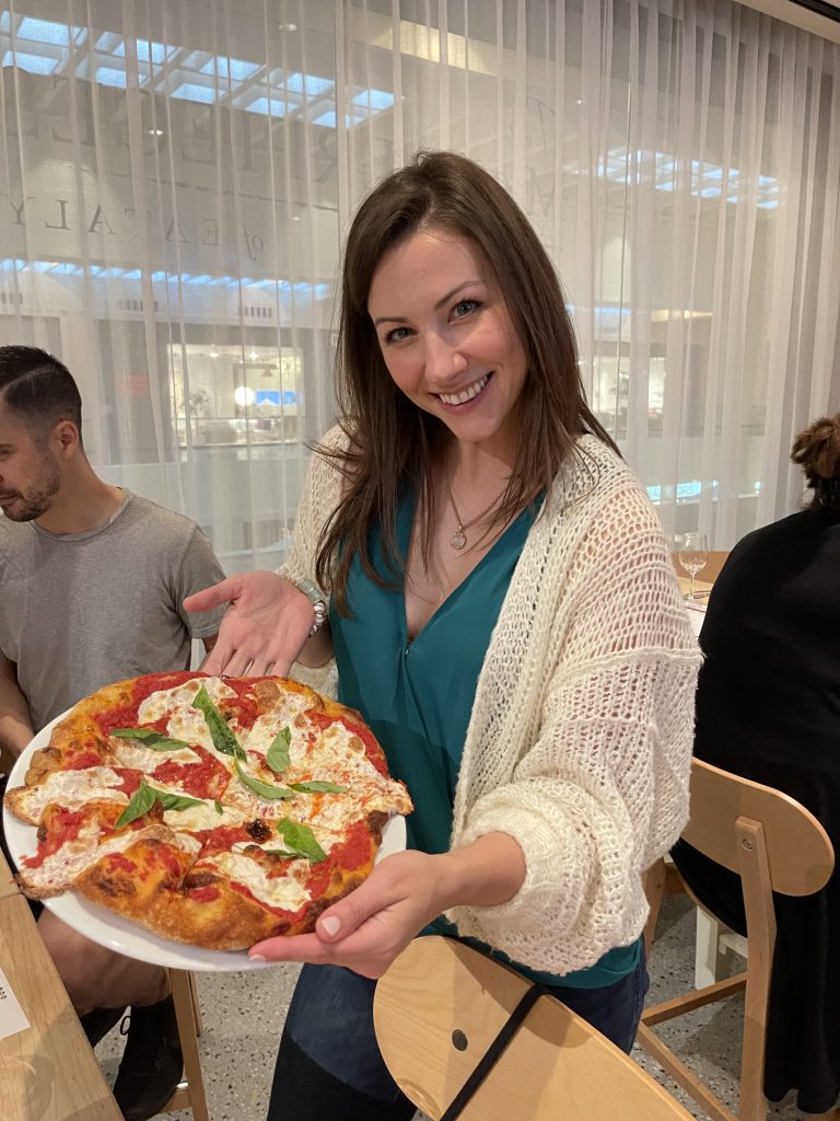 Woman posing with pizza