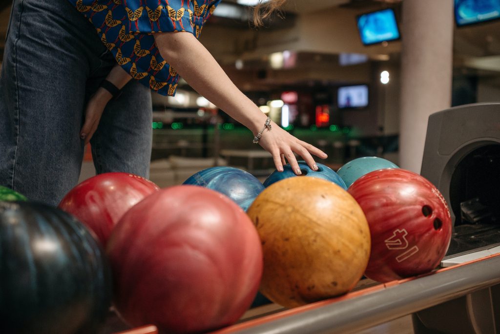 woman selecting bowling ball, bowling date in Dallas