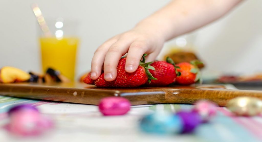toddler hand grabbing strawberries, healthy snacks for toddlers