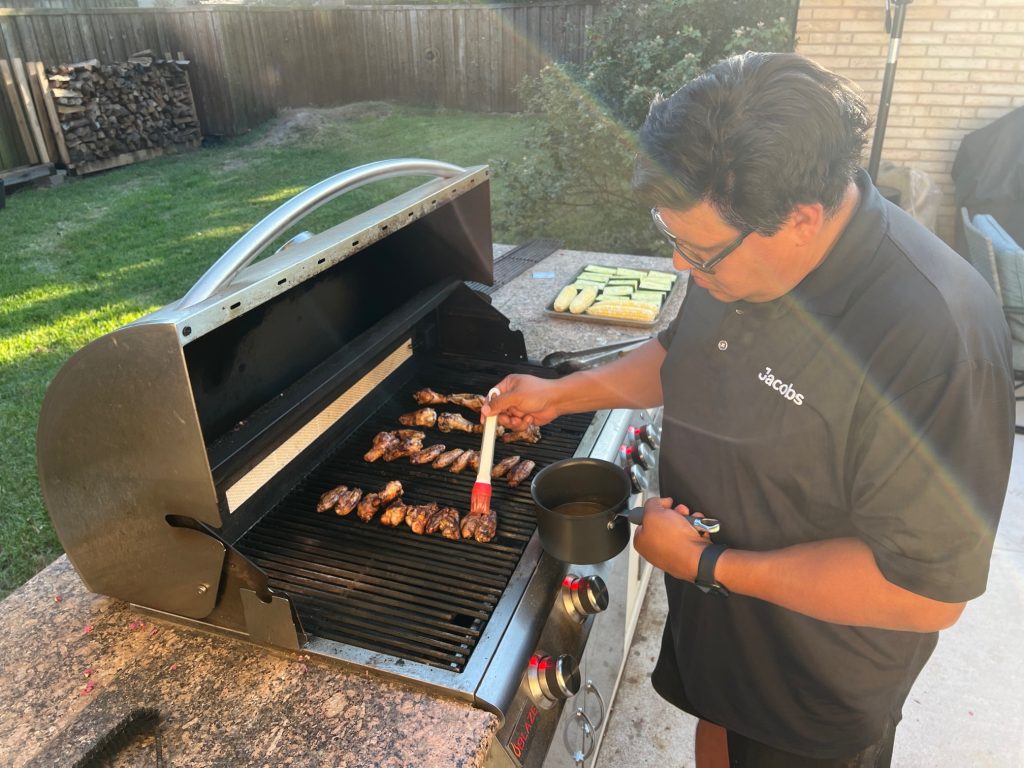 man grilling chicken wings, make entire dinner on the grill