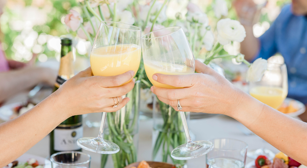 Women toasting mimosas during brunchl