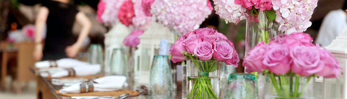 pink flowers in vases on a table at a restaurant