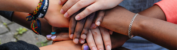close-up of women's joined hands (multiracial)