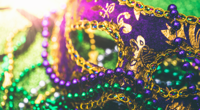 closeup of Mardi Gras mask and green and purple plastic beads