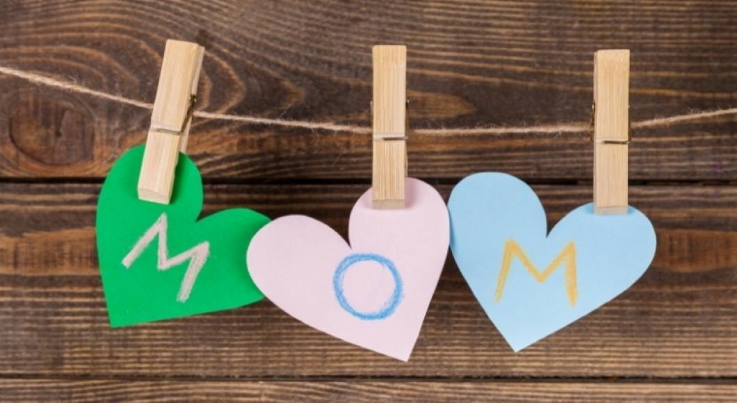 Three hearts, cut out of construction paper, hang on a clothes pins and spell "mom" written in crayon.