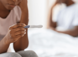 A woman looks at a pregnancy test.