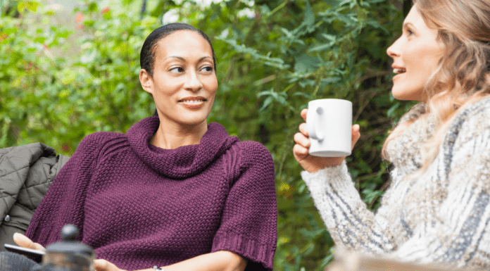Two women talk over coffee.