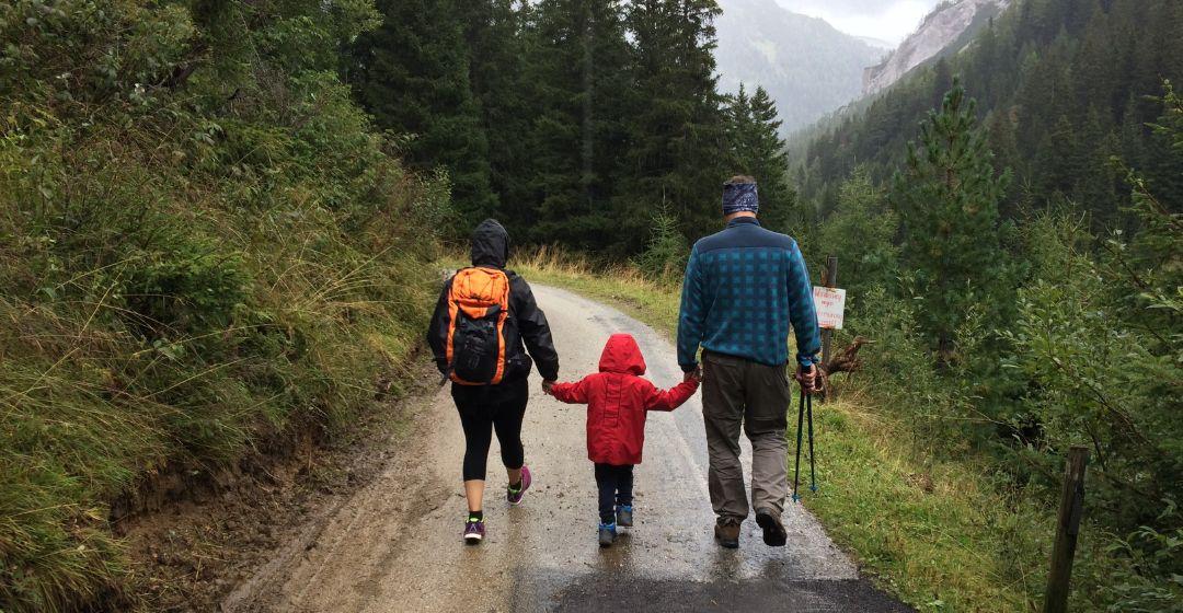 A family walks hand in hand on a hike.
