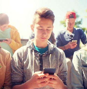 a group of teens all looking at their phones