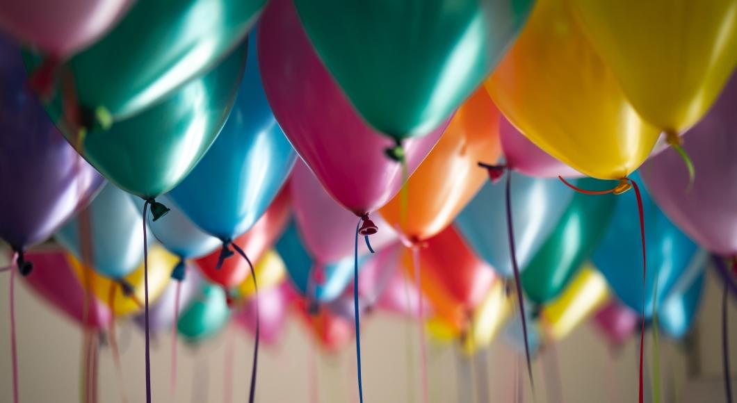 A variety of colored balloons float to the ceiling.