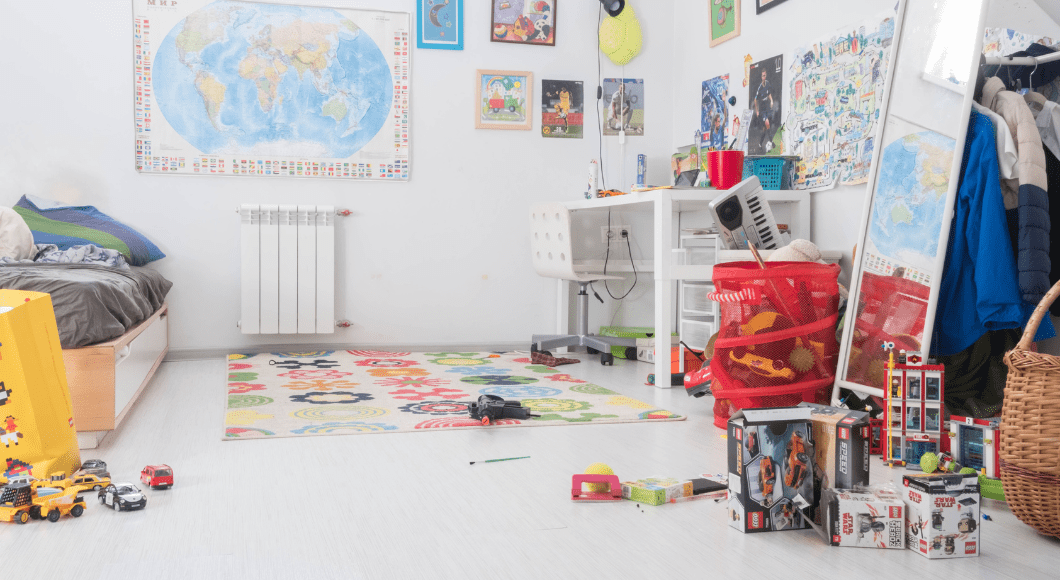 An image of a children's playroom with a desk and toys on the floor.