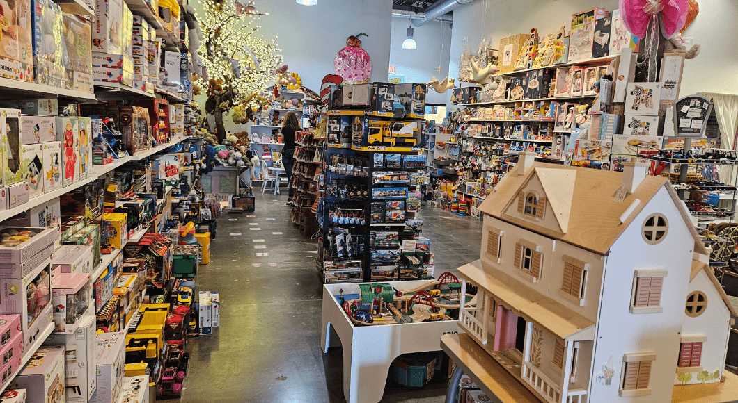 Toy Tree store in Plano. Lit-up tree in back, wooden dollhouse and accessible train set in the foreground.