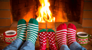A family enjoying cocoa and Christmas socks buy a fireplace.