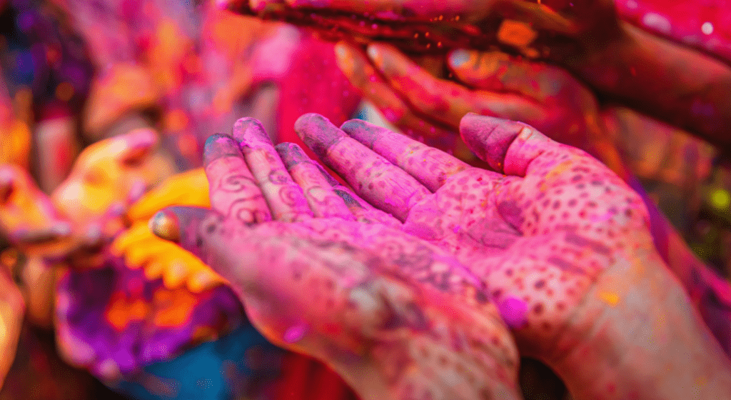 Henna tattoo and powdered color from Holi festival cover a woman's hands