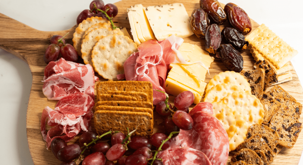 A charcuterie board of crackers, cheese, meats, and fruit makes for a great teacher appreciation gift.